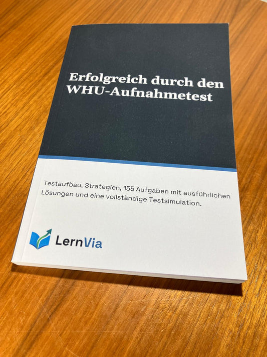 Taschenbuch „Erfolgreich durch den WHU-Aufnahmetest“ von LernVia auf einem Holztisch